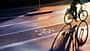 Radweg am Abend. Schild für Fahrrad auf den Asphalt gemalt. Auto und Verkehr im Hintergrund. Radweg am Abend. Schild für Fahrrad auf den Asphalt gemalt. Auto und Verkehr im Hintergrund.