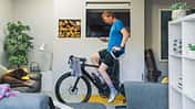 Man using his cycling turbo trainer in the living room