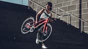 Frau trägt leichtes E-Bike Treppenstufen herab