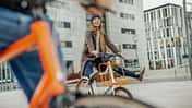 Carefree woman with man riding bicycle in the city