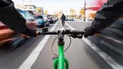 Cyclist drives on the bike path past the traffic jam - First-person view of cyclist/ motion blur