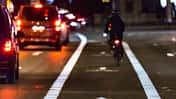 Cyclist drives on the bike path past the traffic jam