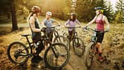 Female mountain bikers in discussion after descending mountain trail