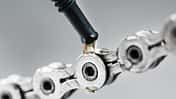 Greasing a bicycle chain with a drop of golden oil close-up on a gray background