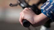 Close up view of a teenagers hand on the bicycle handlebars