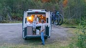 A Couple Experiencing Cozy Van Life Adventure in Autumn Forest