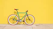 Buntes Fahrrad vor knallgelber Wand 