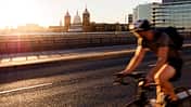 London, verschwommene Bewegung eines schnell fahrenden Radfahrers auf der London Bridge mit Blick auf die St. Paul's Cathedral im Hintergrund