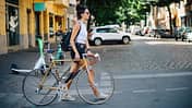 Eine Frau auf dem Fahrrad in Berlin-Neukölln, in der Nähe von Kreuzberg, an einem hellen und sonnigen Sommertag.