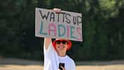 Ein Tour-de-France-Zuschauer hält ein Schild mit "Watts up Ladies" hoch 