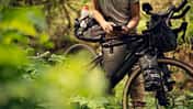 Bikepacker Checking Smartphone On Gravel Bike In Forest