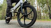 Radfahrer fährt auf einem Radweg im Wald. Fahren mit einem modernen Elektrofahrrad.