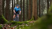 Cyclist riding gravel bike on a forest trail in Germany